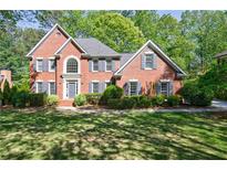 Beautiful two-story brick home with a manicured lawn and mature landscaping at 415 Oak Laurel Ct, Johns Creek, GA 30022