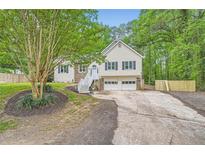 Charming home with a two-car garage, a well-maintained lawn, and beautiful, mature trees at 5640 Rolling Oaks Dr, Cumming, GA 30040