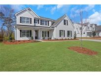Charming two-story home with manicured lawn and classic white facade, complete with black shutters at 6680 Benchwood Path, Cumming, GA 30028