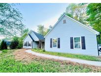 Charming single-story home featuring light blue siding, dark shutters, and a well-manicured lawn at 7675 Lanier View Rdg, Cumming, GA 30041