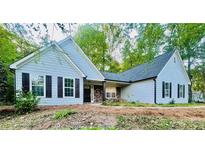 Charming single-story home with light blue siding, black shutters, and a stone-accented front entrance at 7675 Lanier View Rdg, Cumming, GA 30041