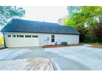 Spacious garage with a large concrete driveway and convenient access to the home's side entrance at 7675 Lanier View Rdg, Cumming, GA 30041