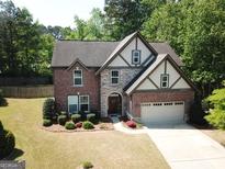 Two-story brick and stone home with well-maintained landscaping and a two-car garage at 3215 Trowbridge Dr, Cumming, GA 30040