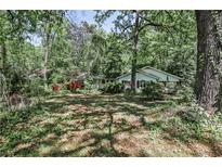 Quaint home nestled amongst mature trees, featuring a red porch and shutters at 1164 Oldfield Rd, Decatur, GA 30030
