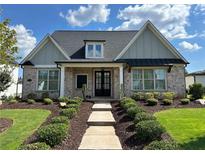 Charming brick home with manicured lawn, symmetrical landscaping, and covered entrance at 3220 Montebello Pkwy, Cumming, GA 30028