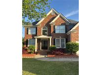Charming two-story brick home with manicured lawn and lovely landscaping, including mature trees and shrubbery at 1943 Blue Heron Way, Lawrenceville, GA 30043