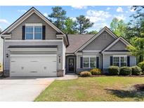 Charming gray two-story home featuring a two-car garage and well-maintained landscaping at 2075 Villa Spring Ct, Dacula, GA 30019