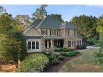 Charming stone facade home with lush landscaping, dormer windows, and inviting front porch at 519 River Estates Pkwy, Canton, GA 30115