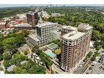 Stunning aerial view of a luxury community with lush greenery, a pool, and city skyline views at 1820 Peachtree Nw St # 1008, Atlanta, GA 30309