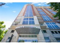 Striking view of The Brookwood exterior showing soaring height, multi-paned windows, and porte-cochere at 1820 Peachtree Nw St # 1008, Atlanta, GA 30309