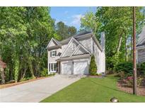 Charming two-story home with a well-manicured lawn, attached garage, and mature trees at 3902 Concord Walk Se Dr, Smyrna, GA 30082