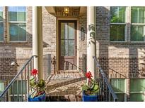 Charming brick home featuring a welcoming front porch with columns, potted plants, and a stately front door at 1200 Virginia Ct # 101, Atlanta, GA 30306