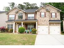 Charming two-story brick home with a well-manicured lawn and attached two-car garage at 3830 Kittery Pt, Snellville, GA 30039
