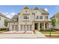 Charming two-story home featuring a three-car garage and a beautifully landscaped front yard at 10265 Grandview Sq, Johns Creek, GA 30097