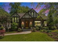 Charming Tudor-style home with a well-manicured lawn, beautiful landscaping, and classic architectural details at 937 E Rock Springs Ne Rd, Atlanta, GA 30306