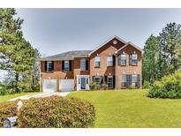 Charming two-story brick home with a well-manicured lawn and a two-car garage at 3710 Burling Rdg, Lithonia, GA 30038