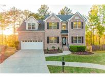 Charming brick two-story home featuring a manicured lawn and an attached two-car garage at 4061 Preserve Trl, Snellville, GA 30039