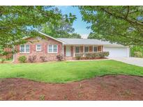 Charming brick home with a lush green lawn and manicured landscaping, showcasing its curb appeal and inviting exterior at 5306 Corinth Cir, Stone Mountain, GA 30087