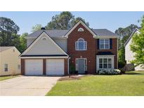 Charming two-story home with brick facade, attached two car garage and well-manicured lawn at 1553 Pinebreeze Dr, Marietta, GA 30062