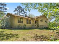 Charming home featuring a well-maintained lawn, inviting entrance, and classic architectural details under a clear blue sky at 2062 Skyhawk Ln, Acworth, GA 30102
