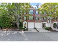 Charming brick townhome featuring a two-car garage, neat landscaping, and classic architectural details at 4912 Waters Edge Trl, Roswell, GA 30075