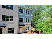 Charming exterior with brick and blue siding, large windows, and well-maintained landscaping at 5443 Blossomwood Sw Trl, Mableton, GA 30126