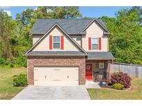 Charming two-story home with a stone accent garage, red shutters, and a landscaped front yard at 100 Cottage Nw Walk, Cartersville, GA 30121