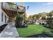 Lush backyard with a wooden deck, patio, and lake access, perfect for outdoor entertaining at 10005 Lakeview Pkwy, Villa Rica, GA 30180