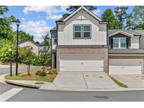 Charming townhome with a two-car garage, brick accents, and well-maintained landscaping at 1385 Vayda Ct, Marietta, GA 30066