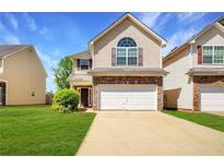 Charming two-story home featuring a two-car garage and manicured lawn, perfect for suburban living at 11151 Aliyah Dr, Hampton, GA 30228