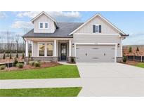 Charming home featuring a two-car garage, well-kept lawn and traditional architectural details at 214 Strawberry Ln, Woodstock, GA 30189