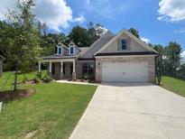 Charming single-story home featuring brick accents, a two-car garage, and a welcoming covered front porch at 350 Brooke View Trl, Canton, GA 30115