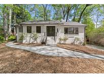 Charming brick home featuring a landscaped front yard, updated windows and inviting entryway steps at 3915 Ivy Ne Rd, Atlanta, GA 30342