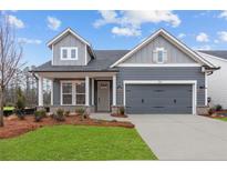 Charming craftsman-style home with gray siding, a two-car garage, and a well-manicured front lawn at 231 Strawberry Ln, Woodstock, GA 30189
