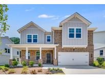 Charming two-story home with a brick and siding exterior, covered porch, and attached two-car garage at 3321 Burkston Pl, Buford, GA 30519
