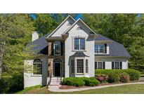 Charming stucco home featuring a well-manicured lawn, arched windows, and a stone accent entry at 1820 Lyon Sw Ave, Atlanta, GA 30331