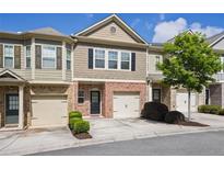 Charming townhome with a brick facade, attached garage, and well-maintained landscaping at 3203 Cyrus Point Nw Ln, Kennesaw, GA 30152