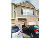 Charming townhome featuring a brick facade, neutral siding, and a welcoming front door with a decorative wreath at 3203 Cyrus Point Nw Ln, Kennesaw, GA 30152