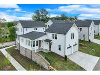 Beautiful two-story home with white siding, black roof and two car garage at 1304 Six Sisters St, Dacula, GA 30019