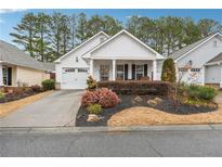 Charming single-story home with a well-manicured lawn, attached garage, and inviting front porch at 142 Jaime Dr, Canton, GA 30114