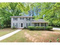 Traditional home with a manicured lawn, dark shutters, and a walkway leading to the front door at 4261 Autumn Hill Dr, Stone Mountain, GA 30083