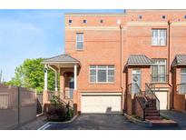 Charming brick townhouse with covered porch, stairs to the front door, and two car garage at 64 Emerson Hill Sq, Marietta, GA 30060