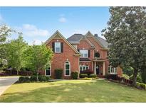 Stately brick home with manicured lawn and mature trees, showcasing classic architectural details and inviting curb appeal at 470 W Magnolia Cir, Johns Creek, GA 30005