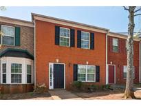 Brick townhouse with black shutters and door, showcasing a classic and inviting facade on a sunny day at 7712 Autry Circle # 204, Douglasville, GA 30134