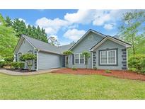 Charming home featuring new landscaping, a grey color scheme, and a well-maintained lawn at 1080 Smoke Hill Ln, Hoschton, GA 30548