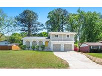 Charming two-story home featuring a beautiful brick facade, arched porch, second story balcony and well-maintained lawn at 4269 Indian Forest Trl, Stone Mountain, GA 30083