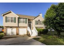 Inviting two-story home with a two-car garage and a manicured lawn at 1501 Buckingham Pl, Stockbridge, GA 30281