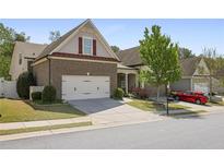 Charming home featuring a two-car garage, landscaped lawn, and traditional architectural details at 123 Heritage Pt, Woodstock, GA 30189