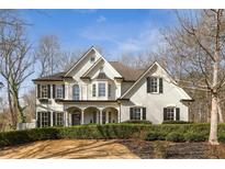 Beautiful two-story home featuring a brick exterior, black shutters, and meticulously maintained landscaping at 5120 Post Oak Tritt Ne Rd, Roswell, GA 30075