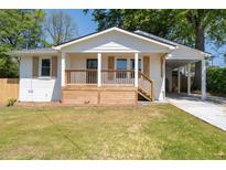 Charming renovated home featuring a wooden porch and convenient carport, perfect for modern living at 1045 Ridgecrest Se Dr, Smyrna, GA 30080